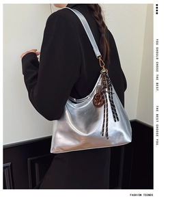 Detalle de bolso de hombro plateado metalizado con adorno de cuerda trenzada suave