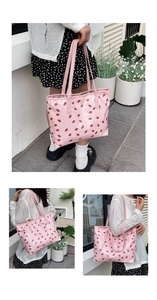 Détail du grand sac cabas rose à imprimé fraises montrant l'espace et les anses