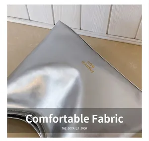 Detalle de cerca del bolso de cuero sintético plateado con letras doradas elegantes