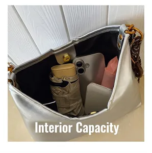 Interior de bolso plateado que muestra gran capacidad para móvil y paraguas