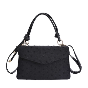 Sac à main noir de luxe avec finitions dorées et design en tissu à pois chic