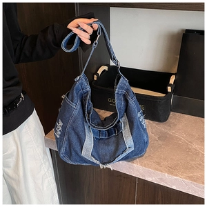 Detail of frayed edges and distressed denim texture on a large navy tote bag