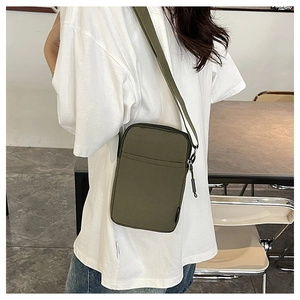 Detail view of olive green crossbody phone bag with adjustable strap and dual zipper pockets