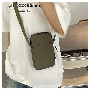 Detail of army green nylon mini crossbody bag with adjustable strap worn by model