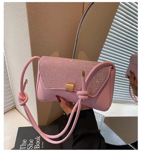 Détail d'un sac à main rose en strass avec rabat scintillant et boucle en métal doré
