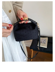 Details der schwarzen bestickten Handtasche mit goldenem Verschluss und Retro-Muster