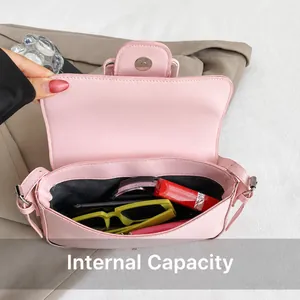 Detailansicht der rosa Leder-Baguette-Tasche innen mit Sonnenbrille und Lippenstift