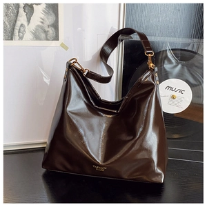 Deep brown glossy leather hobo bag with vintage gold hardware and fashion text