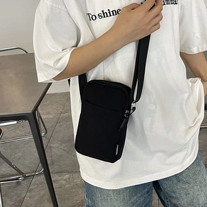 Minimalist black vertical crossbody phone bag with adjustable strap and fashion label