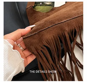 Vue rapprochée des coutures de précision et détails de franges du sac en daim brun
