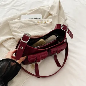 Deep red leather hobo bag with multiple utility pockets showing spacious inner capacity