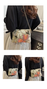 Detail of sequin embroidered crossbody bag with floral pattern and gold chain strap