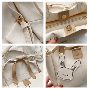 Detail view of cream leather handbag showing gold hardware, stitching and inner structure