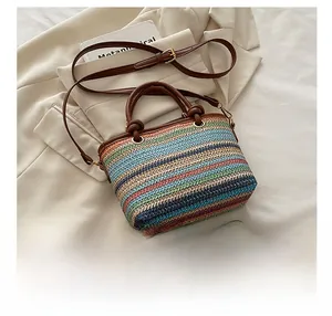 Détail de la texture tissée colorée et de l'anse en cuir marron du sac seau de plage