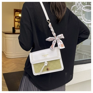 Détail du sac bandoulière bicolore avec motif à damier et décoration en foulard de soie