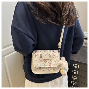 Détail du petit sac blanc texturé avec motifs mignons et breloque lapin en peluche