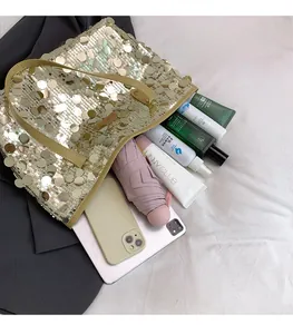Spacious interior of a sequined tote bag showing storage for a tablet and umbrella