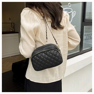 Détail du sac bandoulière matelassé noir avec bandoulière chaîne et double zip