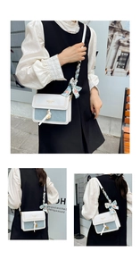 Détail du sac bandoulière contrasté bleu et blanc avec foulard en soie imprimé sur la lanière