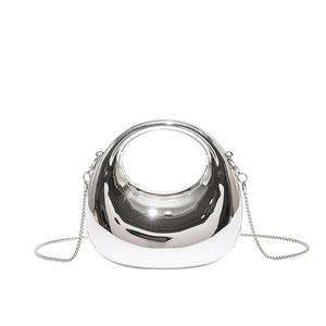 Sleek silver mirror-finish semicircular crossbody bag with modern cutout handle design