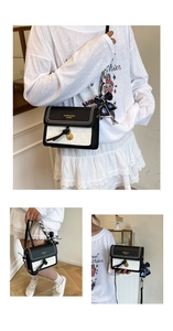 Détail du sac bandoulière bicolore avec foulard en soie et pendentif doré élégant