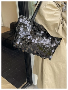 Close-up of black sequin tote bag with mirror finish and Creative Cat label detail