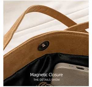 Close-up of magnetic snap closure on vintage suede bag with interior lining detail