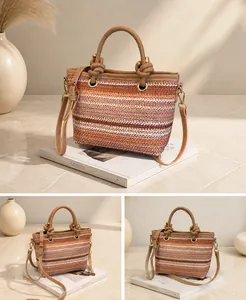 Detail of pink woven straw tote bag with knot handle and adjustable shoulder strap