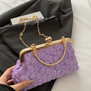 Detail der lila 3D-Rosen-Spitze und des goldenen Kugelverschlusses der Handtasche