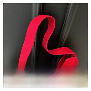 Close-up of wide shoulder strap attachment on a durable red canvas tote bag