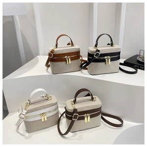 Close-up of four color variants of canvas box bags with leather trim on display