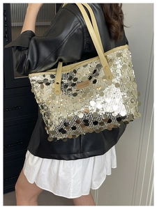 Detail of silver sequin tote bag with leather straps and Creative Cat logo plaque