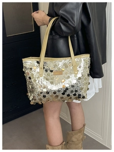 Detail of sequin tote bag with beige leather handles and shimmering metallic finish