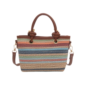 Sac seau ethnique en paille avec rayures multicolores et anses en cuir marron sur fond blanc