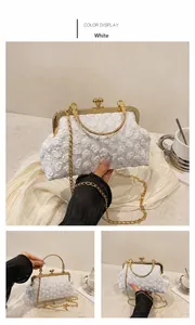 Detail der weißen Spitzen-Abendtasche mit 3D-Blumenstruktur und goldener Metallkette