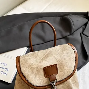 Detail of comfortable brown leather handles on a beige canvas tote bag with metal hardware