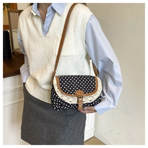 Dettaglio della borsa vintage a pois con pizzo bianco e tracolla regolabile marrone