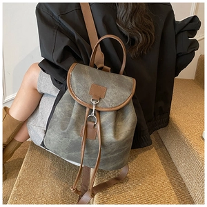 Retro grey-green frosted backpack with brown leather trim shown in a lifestyle setting
