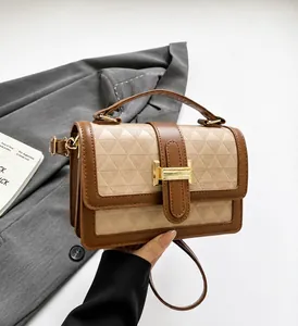 Detail of beige and brown leather handbag featuring geometric triangle embossed patterns
