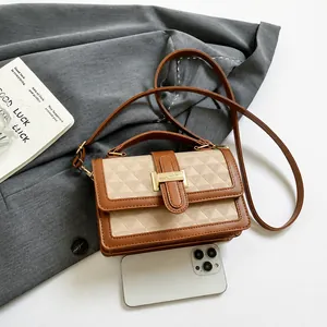 Detail of contrast leather handbag with geometric texture and golden H-clasp