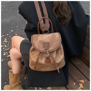 Brown canvas backpack with drawstring closure shown on model for size and fit reference