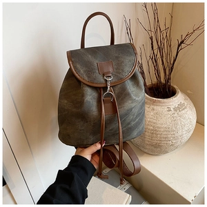 Detail of vintage canvas backpack with brown leather trim and retro metal hook closure