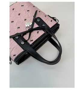 Détail du sac seau en jacquard rose avec motif animal noir et nœud en cuir
