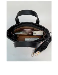 Détail montrant la capacité interne du sac seau noir à nœud avec des articles quotidiens