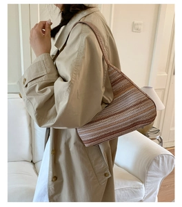 Detail van geweven gestreepte hobo-tas met getextureerd bruin en beige patroon op schouder