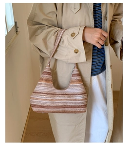 Detail of hand-woven striped hobo bag featuring neutral earth tones and textured finish