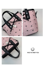 Vistas detalladas de bolso rosa texturizado con lazo negro y colgante de corazón