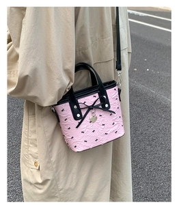 Détail du sac rose texture bulles avec nœuds noirs et pendentif en forme de cœur