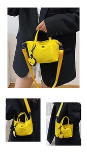 Détail du sac dumpling en nylon jaune vif avec breloque panda et bandoulière réglable