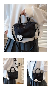 Détail du sac dumpling en nylon noir avec pendentif panda et bandoulière réglable